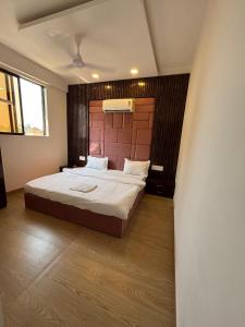 a bedroom with a large bed with a wooden headboard at Villa 37 in Dhamni +15 photos
