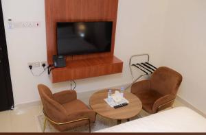 a living room with a table and chairs and a television at شقق نور الفخامه المخدومه in Buraydah