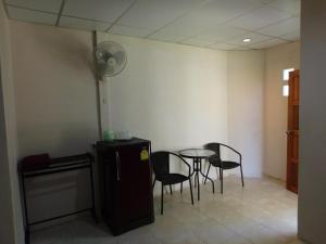 a room with a table and chairs and a refrigerator at 057 รีสอร์ท in Ban Huai To