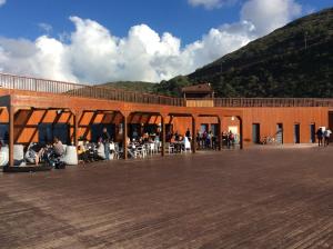 a group of people sitting outside of a building at Beach House Ericeira in Ericeira