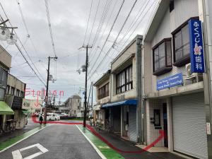 an empty street in a city with buildings at Wonder House in Shingū