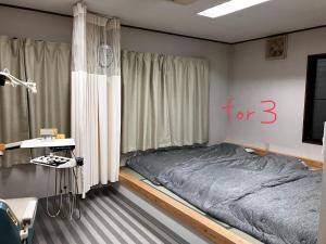 a bedroom with a bed with a for sign on the wall at Wonder House in Shingū