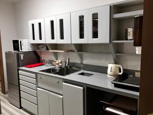 a small kitchen with white cabinets and a sink at Wonder House in Shingū