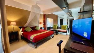 a bedroom with a bed and a flat screen tv at Siam Piman Hotel in Bangkok