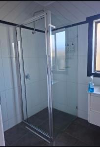 a shower with a glass door in a bathroom at Ocean views in Portland
