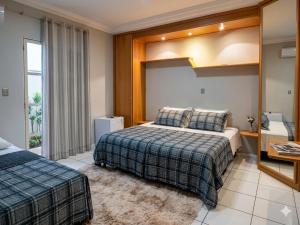 a hotel room with two beds and a window at Londrina Hostel Il in Londrina