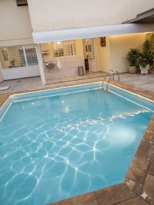 a large blue swimming pool in a building at Londrina Hostel Il in Londrina +11 photos