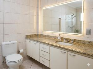 a bathroom with a toilet and a sink and a mirror at Londrina Hostel Il in Londrina