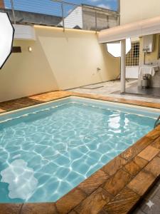 a swimming pool with blue water in a house at Londrina Hostel Il in Londrina