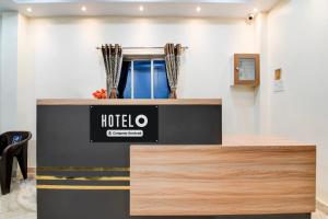 a hotel counter with a sign on top of it at Super Hotel O Shalimar Railway Junction Howrah in Garden Reach