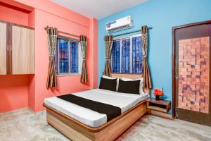 a bedroom with a bed and two windows at Super Hotel O Shalimar Railway Junction Howrah in Garden Reach +32 photos