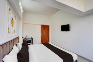 a bedroom with a large bed and a television at Super OYO Collection O Prayag Railway Junction in Colonelganj +36 photos