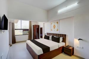 a bedroom with a bed and a television in it at Super OYO Collection O Prayag Railway Junction in Colonelganj