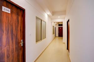 a corridor with a wooden door and a hallway with paintings at Super OYO Collection O Prayag Railway Junction in Colonelganj