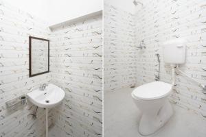 a white bathroom with a toilet and a sink at Super OYO Collection O Prayag Railway Junction in Colonelganj