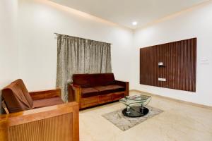 a living room with a couch and a glass table at Super Hotel O Mysore Zoological Park Formerly Queens Comfort in Mysore