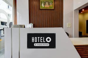 a hotel sign sitting on top of a bed at Super Hotel O Mysore Zoological Park Formerly Queens Comfort in Mysore