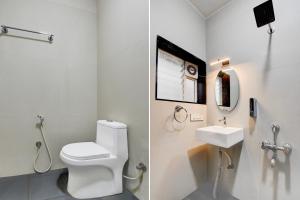 a white bathroom with a toilet and a sink at Super Hotel O Mysore Zoological Park Formerly Queens Comfort in Mysore