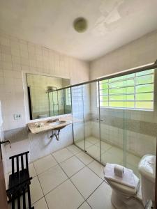 a bathroom with a glass shower and a toilet at Pousada do Sino - 2 min do Capivari in Campos do Jordão +57 photos