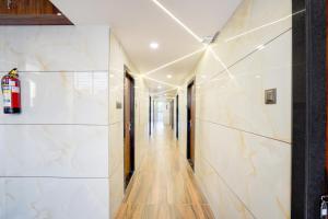 a hallway with white marble walls and wooden floors at Super Townhouse Rajendra Nagar Main Road in Indore