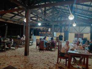 a group of people sitting at tables in a restaurant at Playa Encantada Beach Resort in El Nido