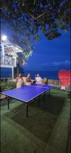 a group of people standing around a ping pong table at White beach Villa in Panglao Island