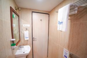 a bathroom with a sink and a toilet and a mirror at The Altruist Andheri Hotel in Mumbai +29 photos