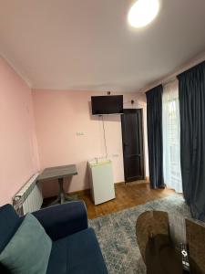 a living room with a blue couch and a table at Guest House Seno in Dilijan