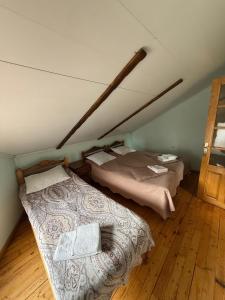 two beds in a room with a attic at Guest House Seno in Dilijan