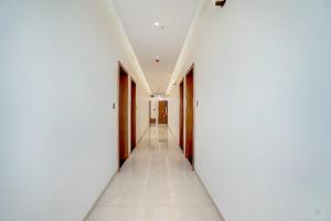 a corridor of a building with white walls and a long hallway at Super Townhouse Oak T. Narasipura Road Formerly Hotel Nishara in Mysore +36 photos