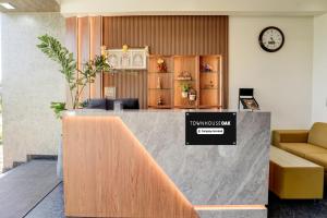 a lobby with a counter with a clock on the wall at Super Townhouse Oak T. Narasipura Road Formerly Hotel Nishara in Mysore