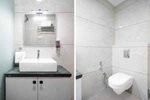 a white bathroom with a sink and a toilet at Super Townhouse Oak T. Narasipura Road Formerly Hotel Nishara in Mysore