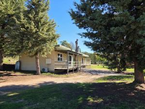 a house with trees in front of it at Cooma Holiday Park in Cooma
