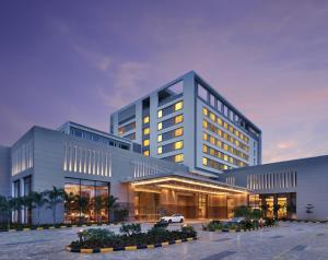 a building with a car parked in front of it at Courtyard by Marriott Madurai in Madurai