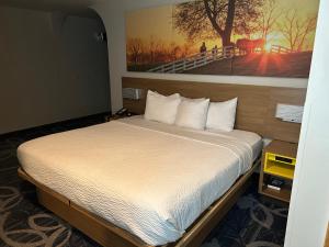 a bedroom with a large bed with white sheets at Days Inn by Wyndham Laramie in Laramie +10 photos