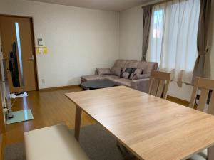 ein Wohnzimmer mit Sofa und Tisch in der Unterkunft Bon Clair in Sunagawa