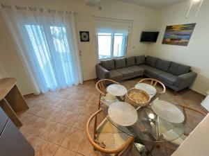 a living room with a glass table and a couch at Infinity blue House Skiathos in Skiathos