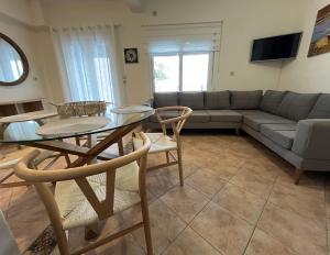 a living room with a couch and a table and chairs at Infinity blue House Skiathos in Skiathos