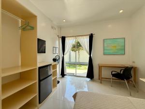 a bedroom with a bed and a desk and a window at Ivorys Guesthouse in Panglao Island