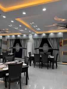 a restaurant with tables and chairs in a room at Crystal Crown Hotel in Peshawar