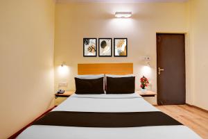 a bedroom with a large bed and two pictures on the wall at OYO Townhouse Singapore Mall Formerly Hotel Sunshine in Lucknow +26 photos