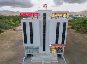a white building with a sign on top of it at F&M Grand Hotel in Ibri