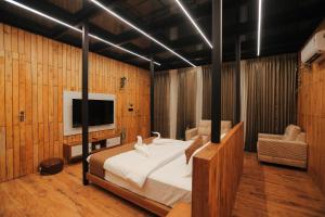 a bedroom with a bed and a television in it at HoneyStone Resort in Sultan Bathery