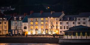 a group of buildings next to the water at night at Richmond Hotel in Aberystwyth