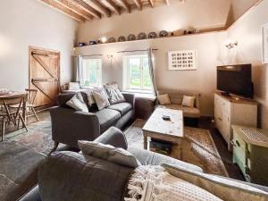a living room with two couches and a table at Kingfisher Oast in Hollingbourne
