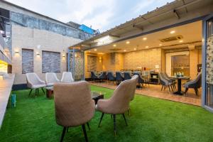an outdoor patio with chairs and tables and grass at Hotel Vanson Villa, City Centre - With Free Airport & Train Station Pickup in New Delhi