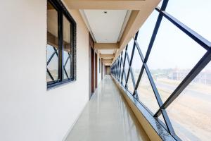 an empty corridor in a building with windows at Townhouse GIDC Ankleshwar Formerly Studio 60 in Kosamri