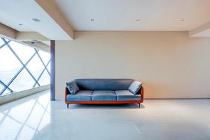 a blue couch in a room with a large window at Townhouse GIDC Ankleshwar Formerly Studio 60 in Kosamri