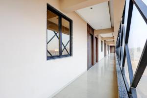 an empty corridor in a building with windows at Townhouse GIDC Ankleshwar Formerly Studio 60 in Kosamri +27 photos