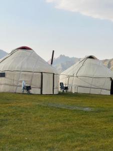 two large tents in a field of grass at NOMAD KEL-SUU Yurt Camp in Kol-Suu